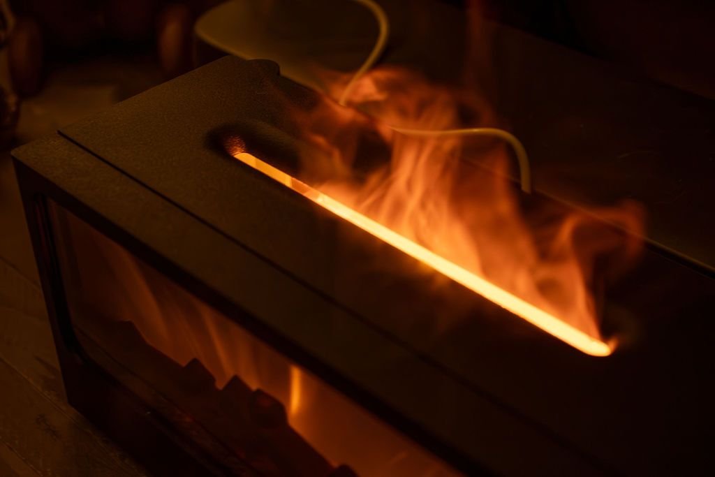 Close-up van de bovenkant: de nevel komt uit een smalle sleuf, met warm licht erdoorheen